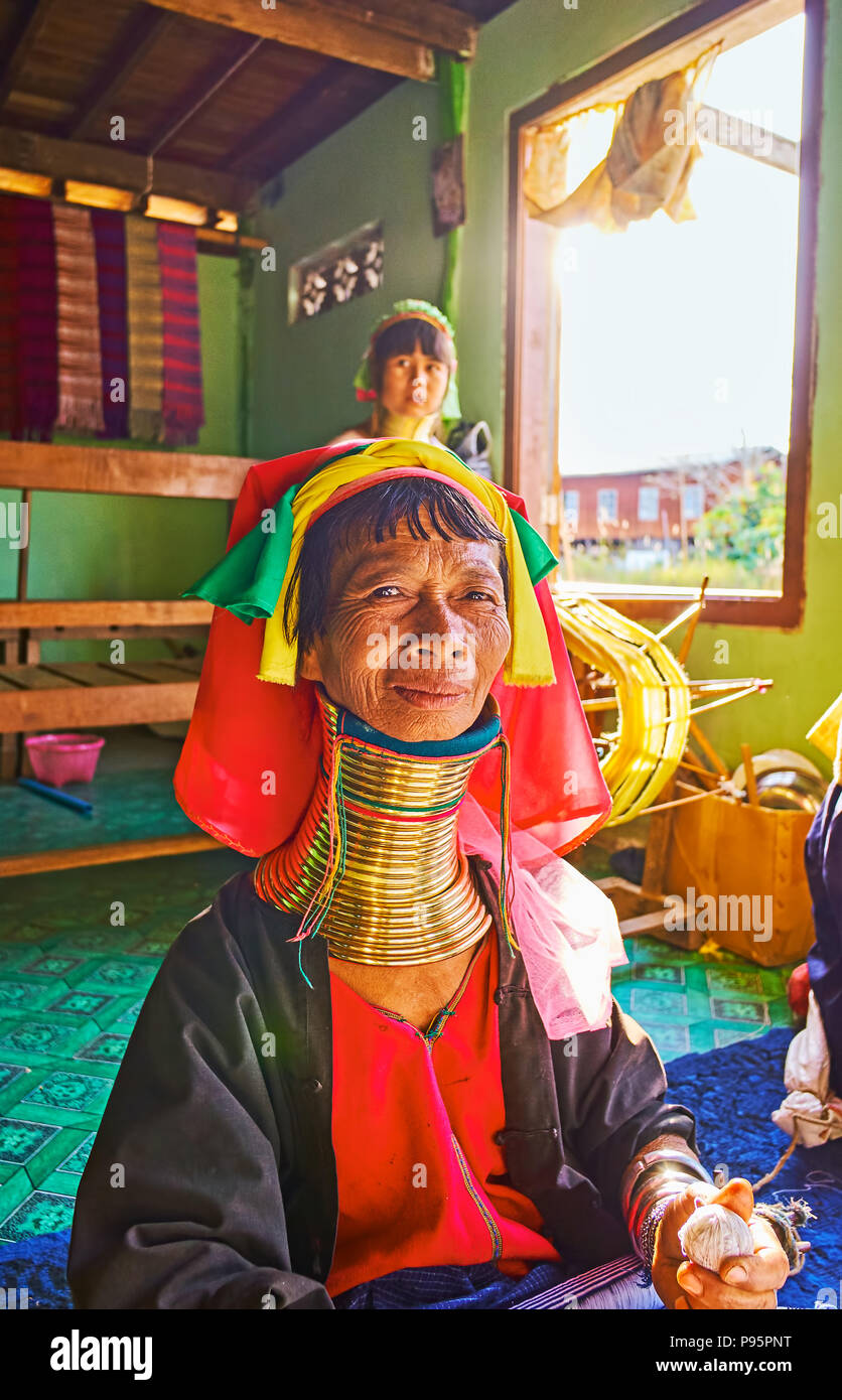 INLE LAKE, MYANMAR - FEBRUARY 18, 2018: The portrait of senior Padaung Kayan long neck woman in traditional colorful headscarf and numerous brass rin Stock Photo