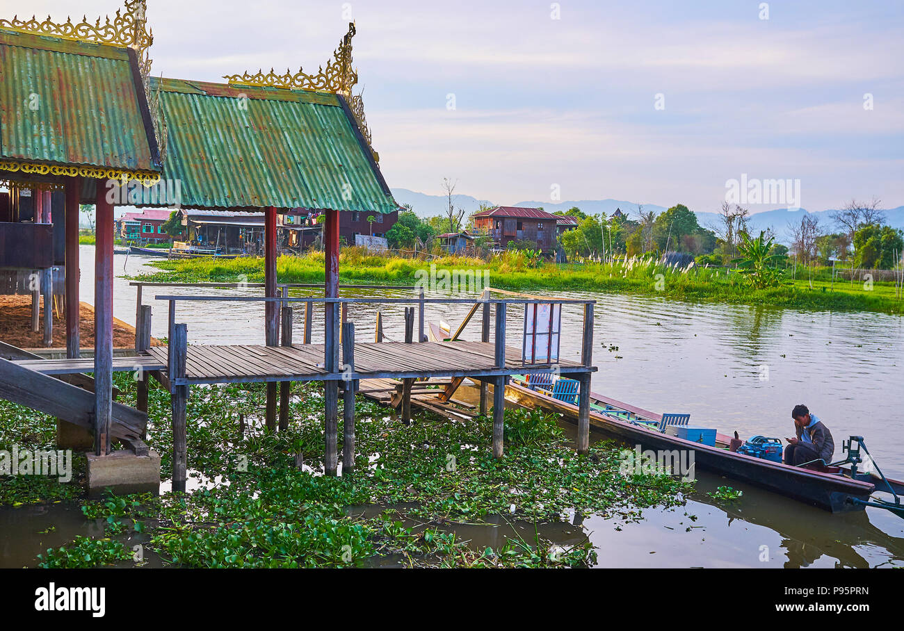 YWAMA, MYANMAR - FEBRUARY 18, 2018: The beautiful stilt porch of Nga Phe Chaung Monastery of jumping cats with green lotus plants, growing around it a Stock Photo