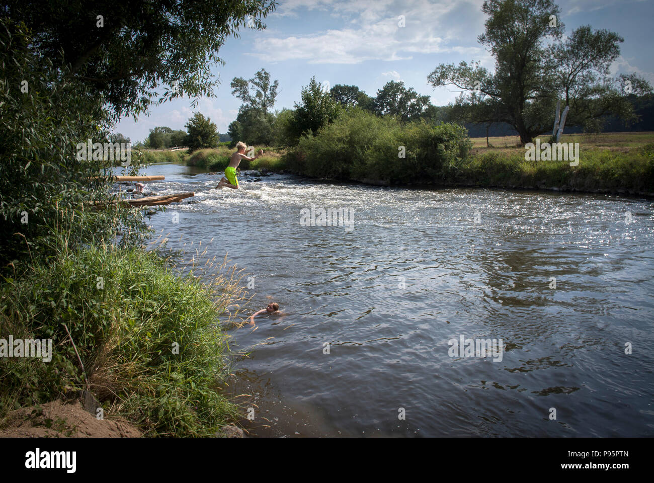 Children play at the river Oder–Neisse at the most eastern part of Germany. Poland on the left bank and Germany on the right. Stock Photo