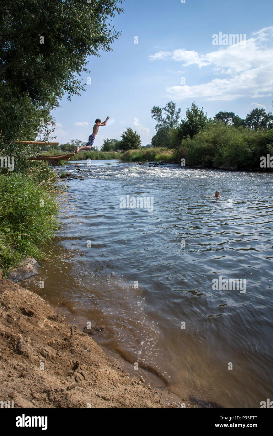 Children play at the river Oder–Neisse at the most eastern part of Germany. Poland on the left bank and Germany on the right. Stock Photo