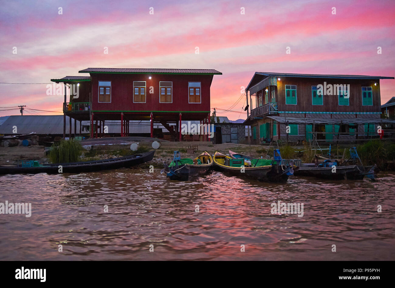The cloudy twilight sky over the stilt houses of Nyaungshwe tourist village, Inle Lake, Myanmar. Stock Photo