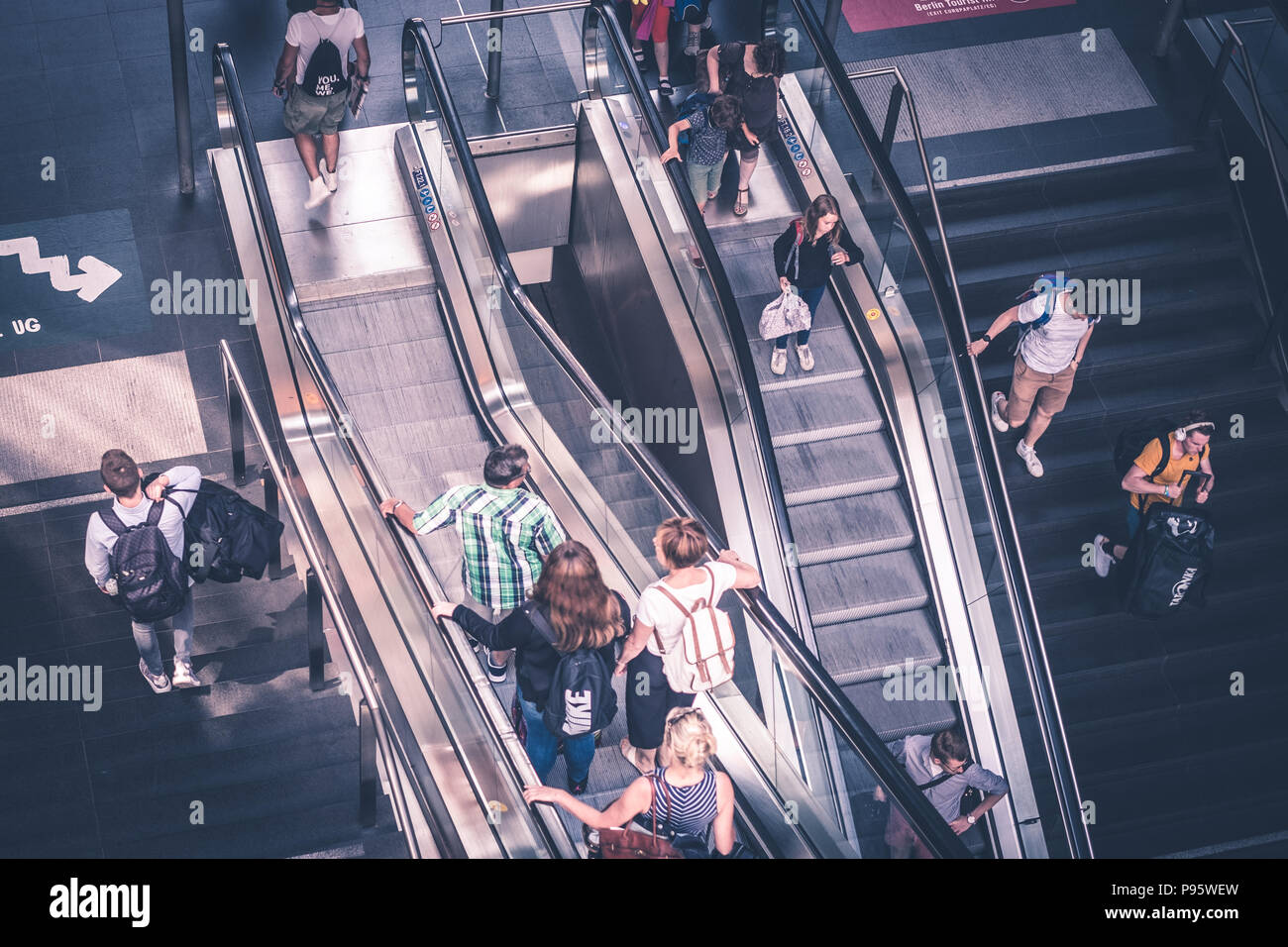 Berlin, Germany - july 2017: Traveling people with luggage on escalator inside main train station (Hauptbahnhof)   in Berlin, Germany Stock Photo