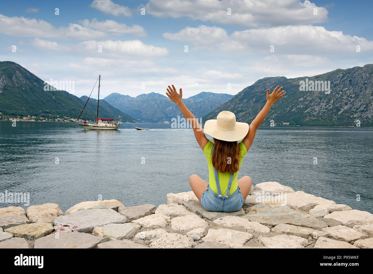 The girl welcomes the sailboat Kotor bay Montenegro summer vacation Stock Photo