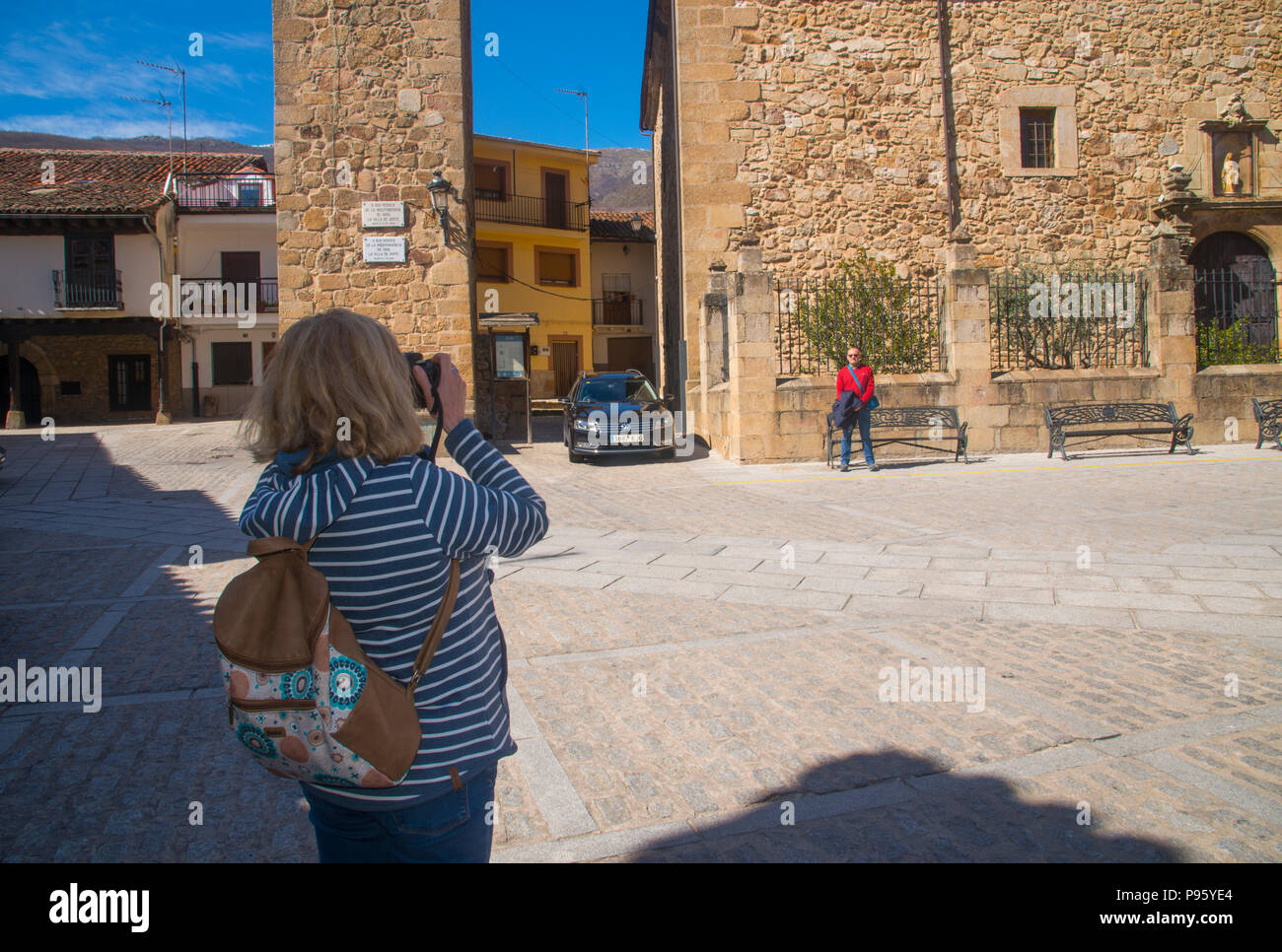 Woman taking photos of her husband at the Main Square. Jerte, Caceres province, Extremadura, Spain. Stock Photo