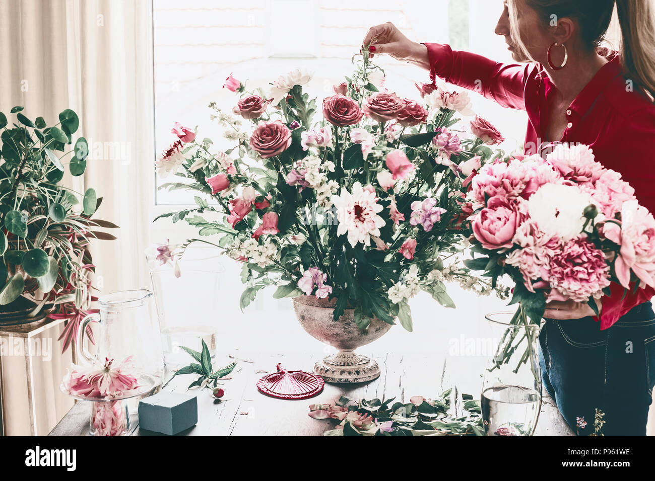 Florist women make beautiful big festive event classical bouquet with roses  and other flowers in urn vase on table at window, lifestyle Stock Photo -  Alamy