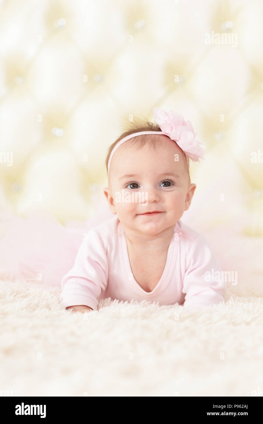 Cute charming girl in pink dress on bed at home Stock Photo - Alamy