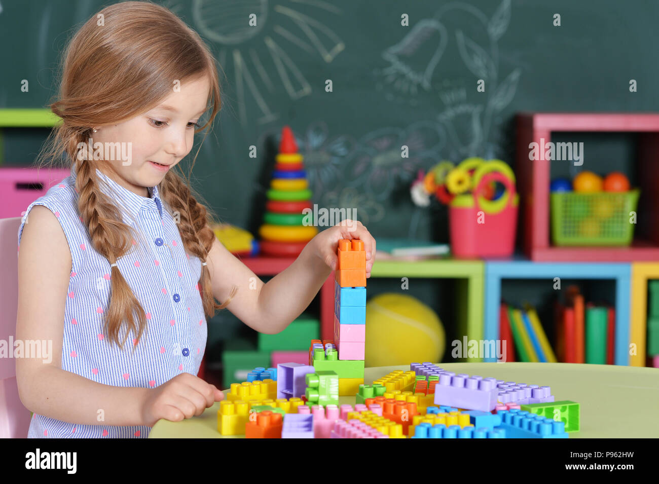 Adorable little girl playing with colorful plastic blocks Stock Photo ...