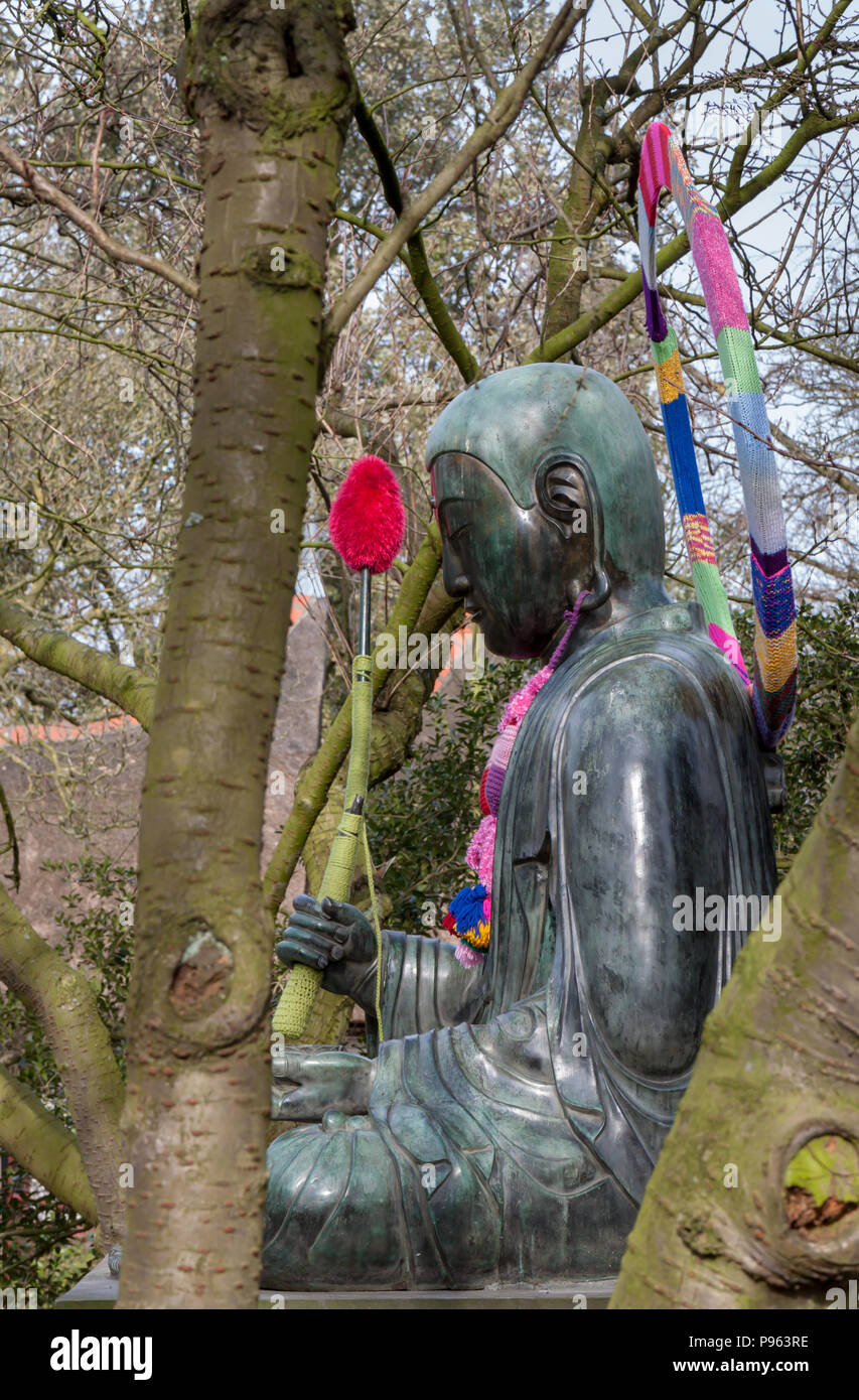 Buddha bronze Statue decorated with wool from a yarn-bombing in Amsterdam, The Netherlands Stock Photo