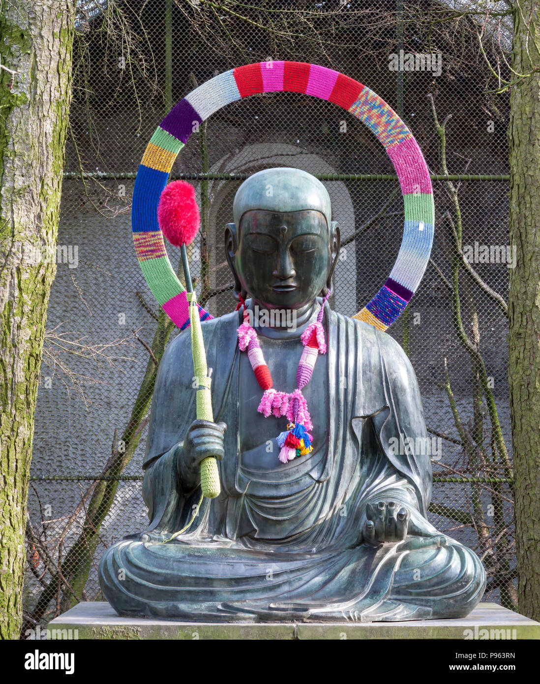 Buddha bronze Statue decorated with wool from a yarn-bombing in Amsterdam, The Netherlands Stock Photo