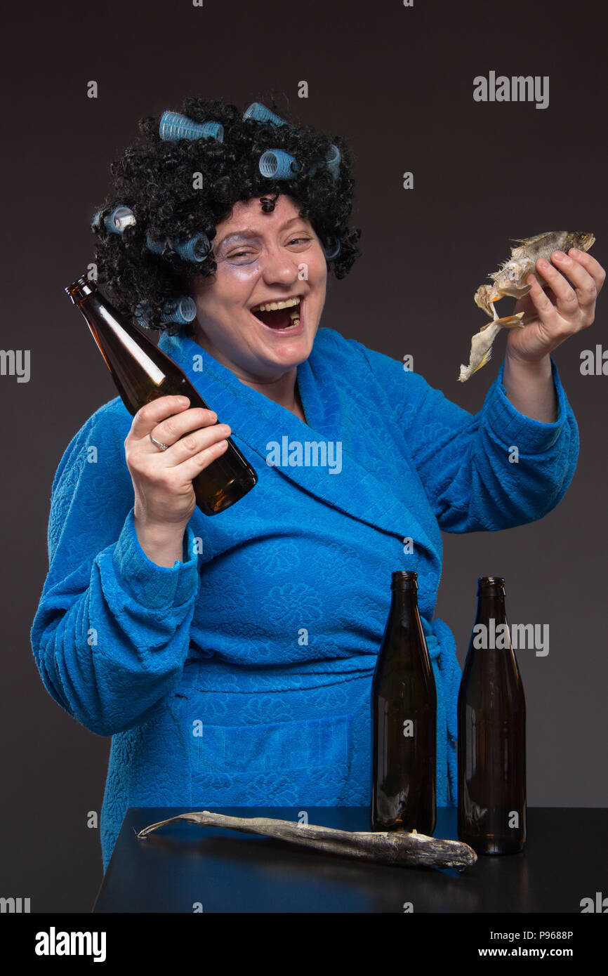 Lonely middleaged woman drinking beer and vodka from a glass tumbler