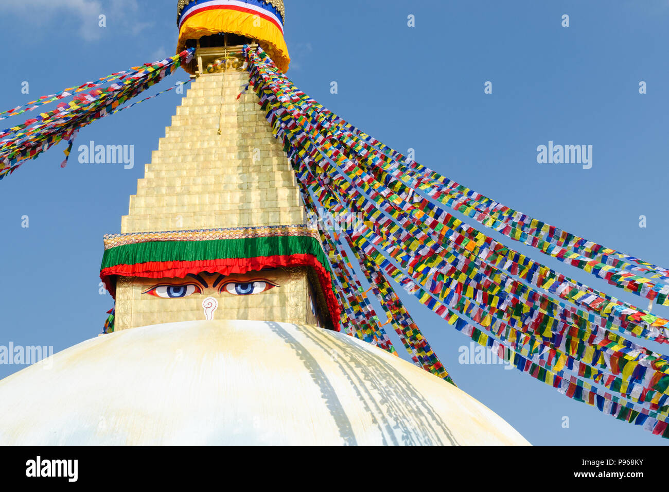 Close-Up shot of Buddha eyes, white stupa and the praying flags in Boudhanath or Buddha Stupa Stock Photo