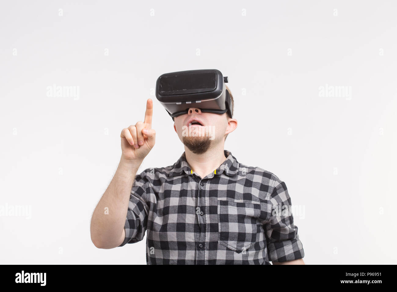 Man wearing virtual reality glasses raising his hand Stock Photo - Alamy