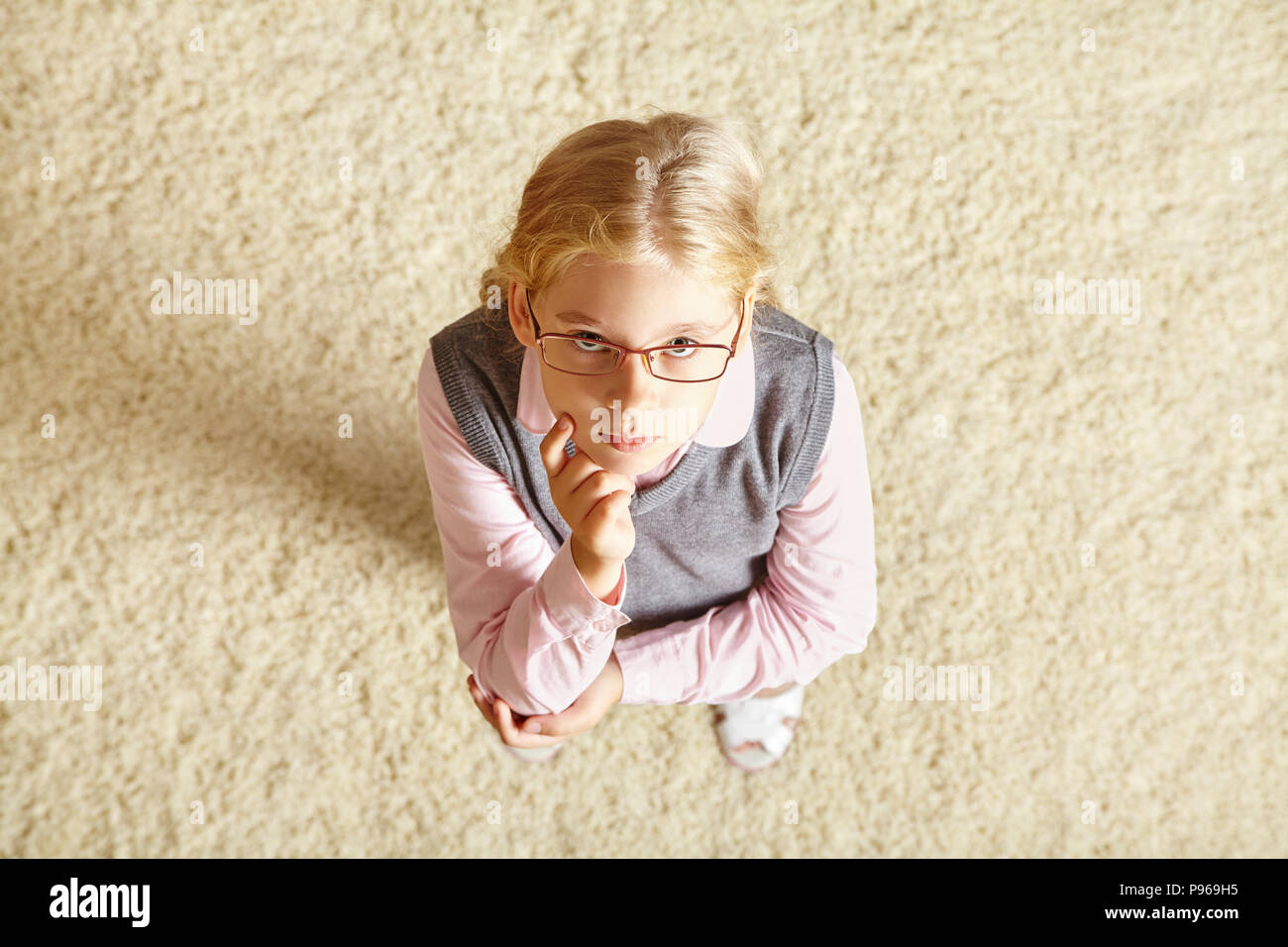 school age girl with glasses on a carpet Stock Photo