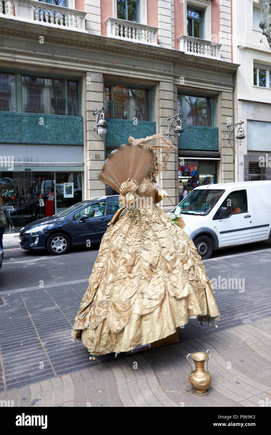 Barcelona, Spain. April 19, 2017: Woman simulating sculpture of a woman with 18th century costume of golden color motionless on the Rambla of Saint Jo Stock Photo
