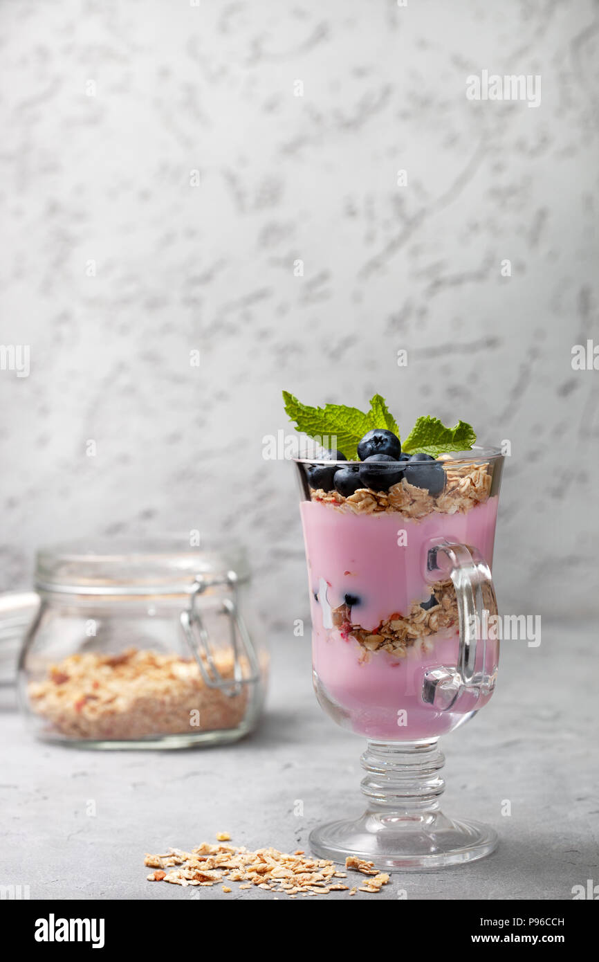 yoghurt with muesli, blueberries, banana in a glass for a healthy breakfast. Stock Photo