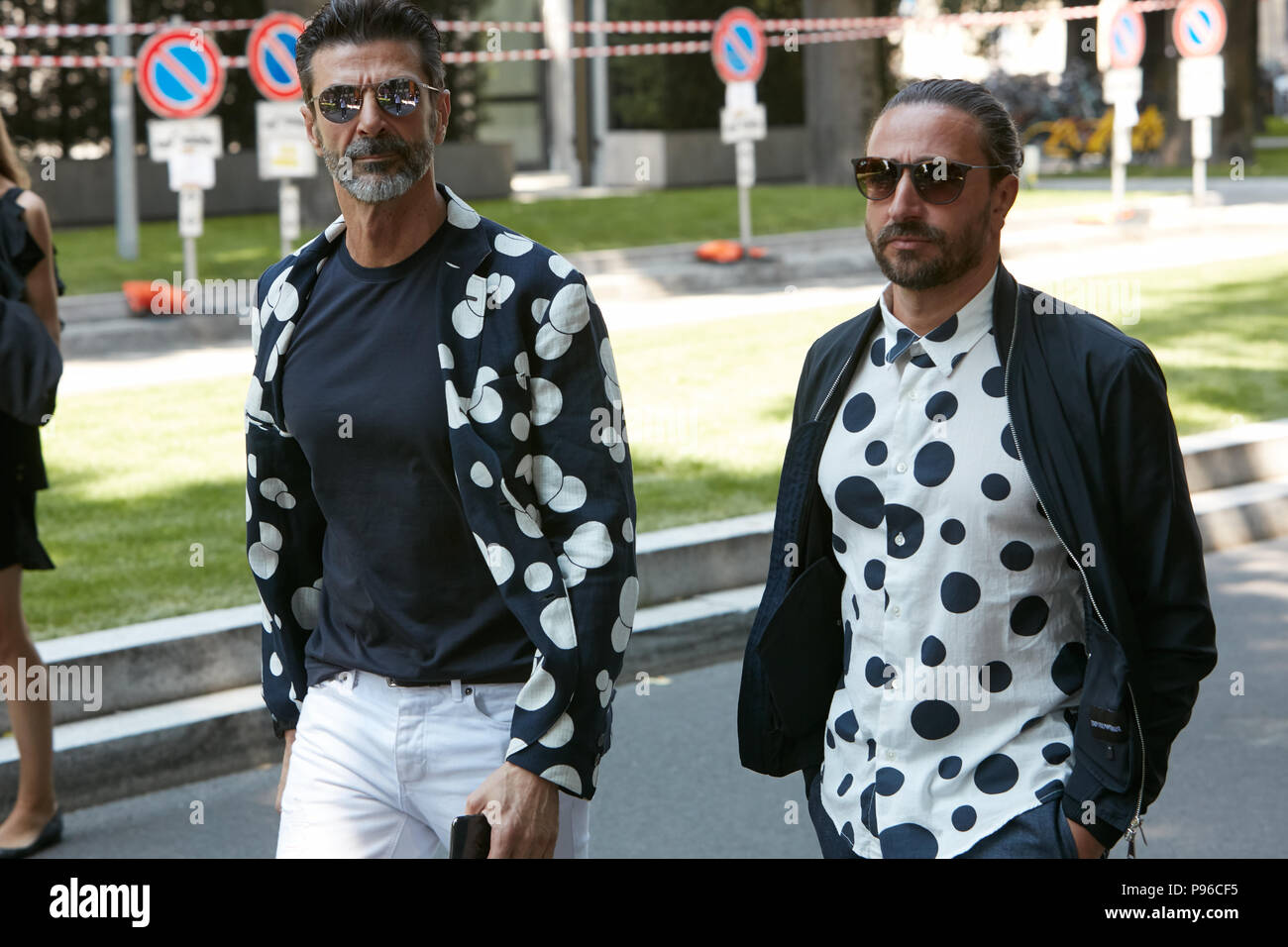 MILAN - JUNE 18: Men with blue and white polka dot jacket and shirt before Giorgio Armani fashion show, Milan Fashion Week street style on June 18, 20 Stock Photo