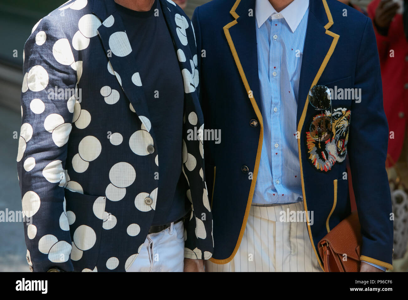 MILAN - JUNE 18: Man with blue and white polka dot jacket and blue Gucci jacket with tiger before Giorgio Armani fashion show, Milan Fashion Week stre Stock Photo