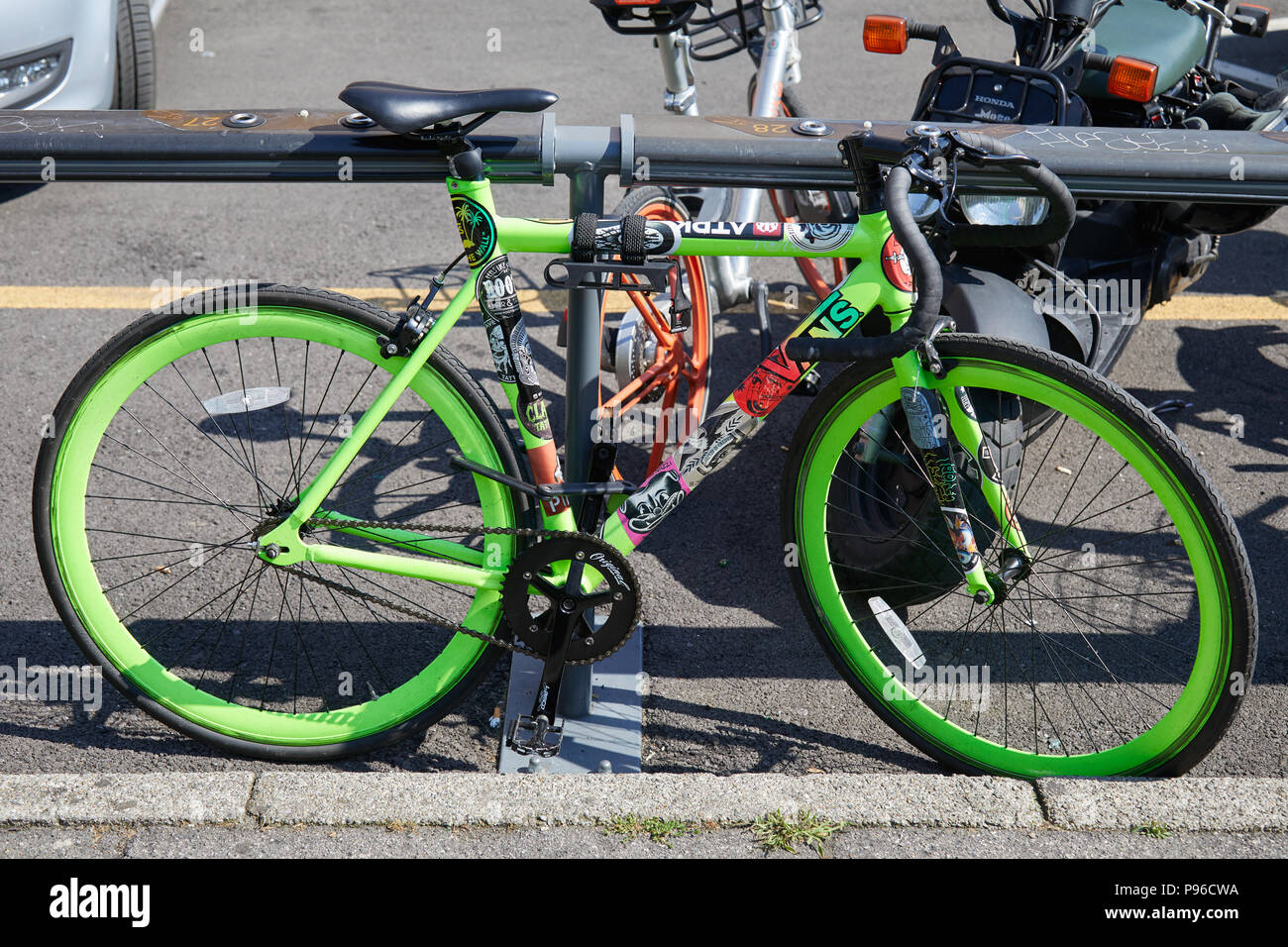 MILAN - JUNE 18: Single speed green bike with stickers seen before Pal Zileri fashion show, Milan Fashion Week street style on June 18, 2018 in Milan. Stock Photo