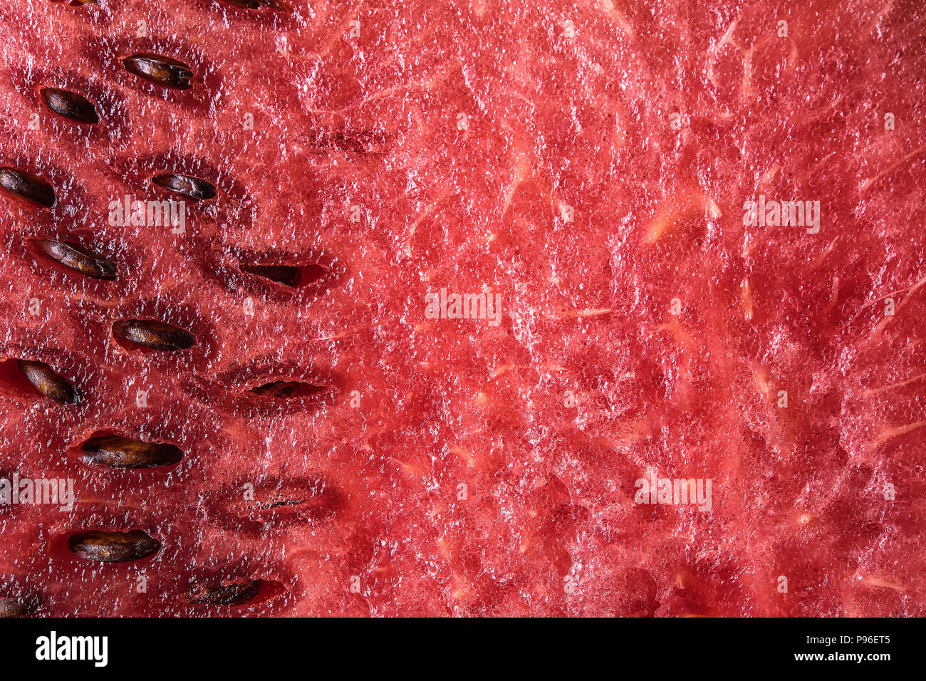 Macro of freshly cutted ripe red watermelon with seeds. Healthy eating and summer atmosphere concept. Highly detailed background with copy space. Stock Photo
