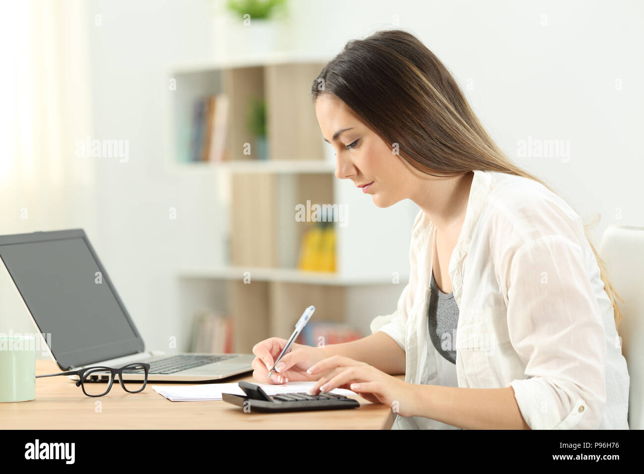 Side view portrait of a serious woman doing accounting at home Stock Photo