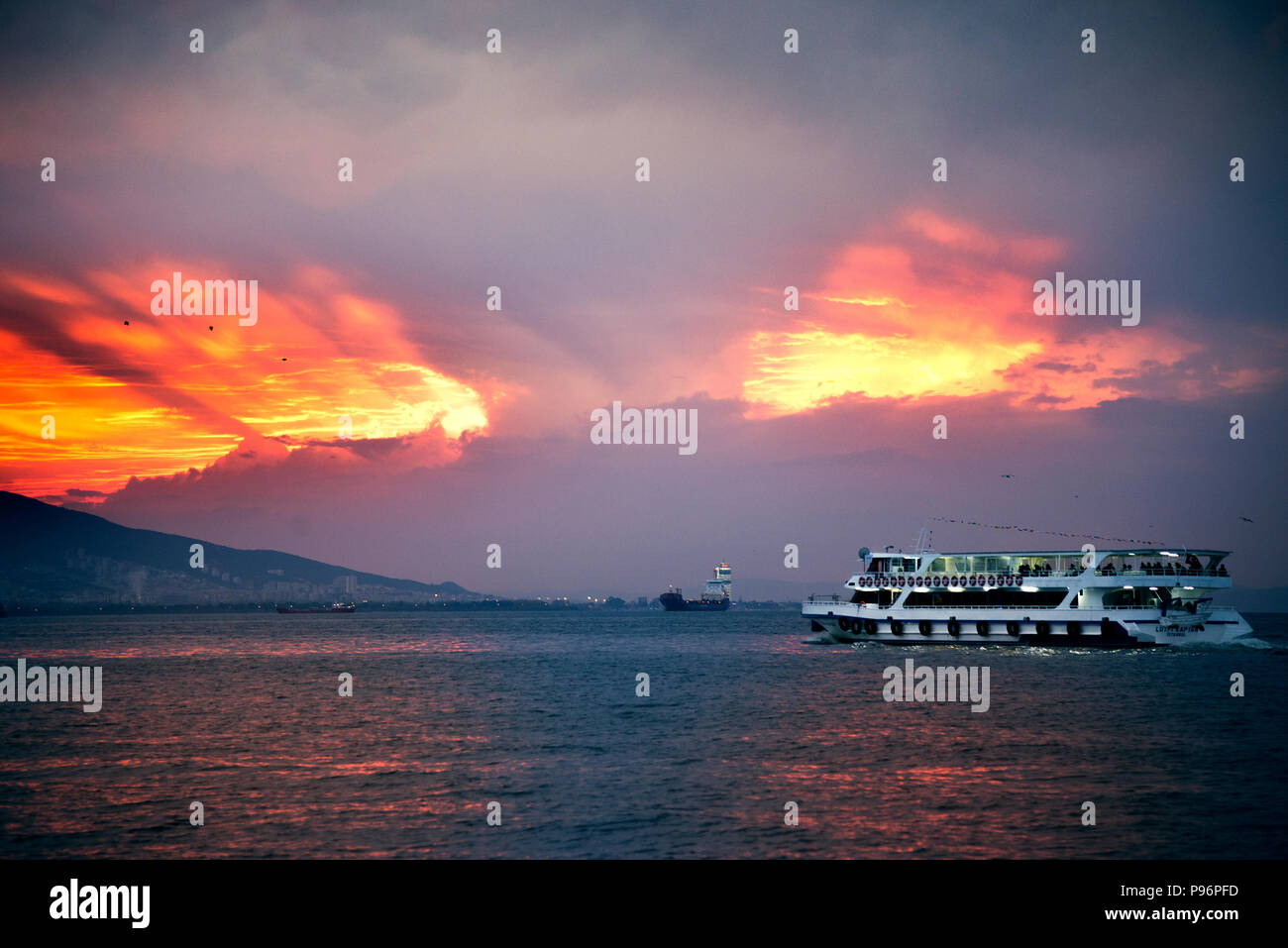 Izmir, Turkey - October 28, 2018. Steamboat on the aegean sea and Izmir bay with passengers and on cloudy sunset. Stock Photo