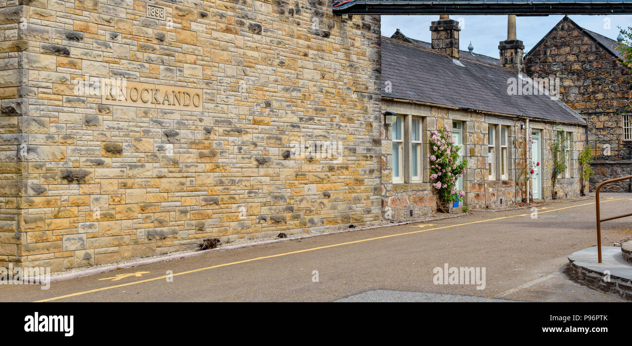 KNOCKANDO WHISKY DISTILLERY MORAY SCOTLAND WALL WITH NAME CARVED IN STONE AND ROSES AROUND AN OLD BUILDING NEAR SPEYSIDE WAY OR TRAIL Stock Photo