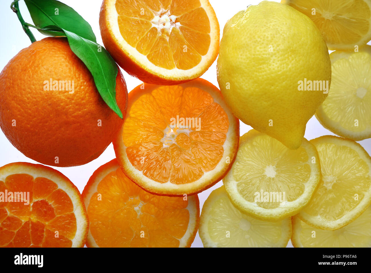 Oranges and lemons whole and sliced on bright background Stock Photo Alamy