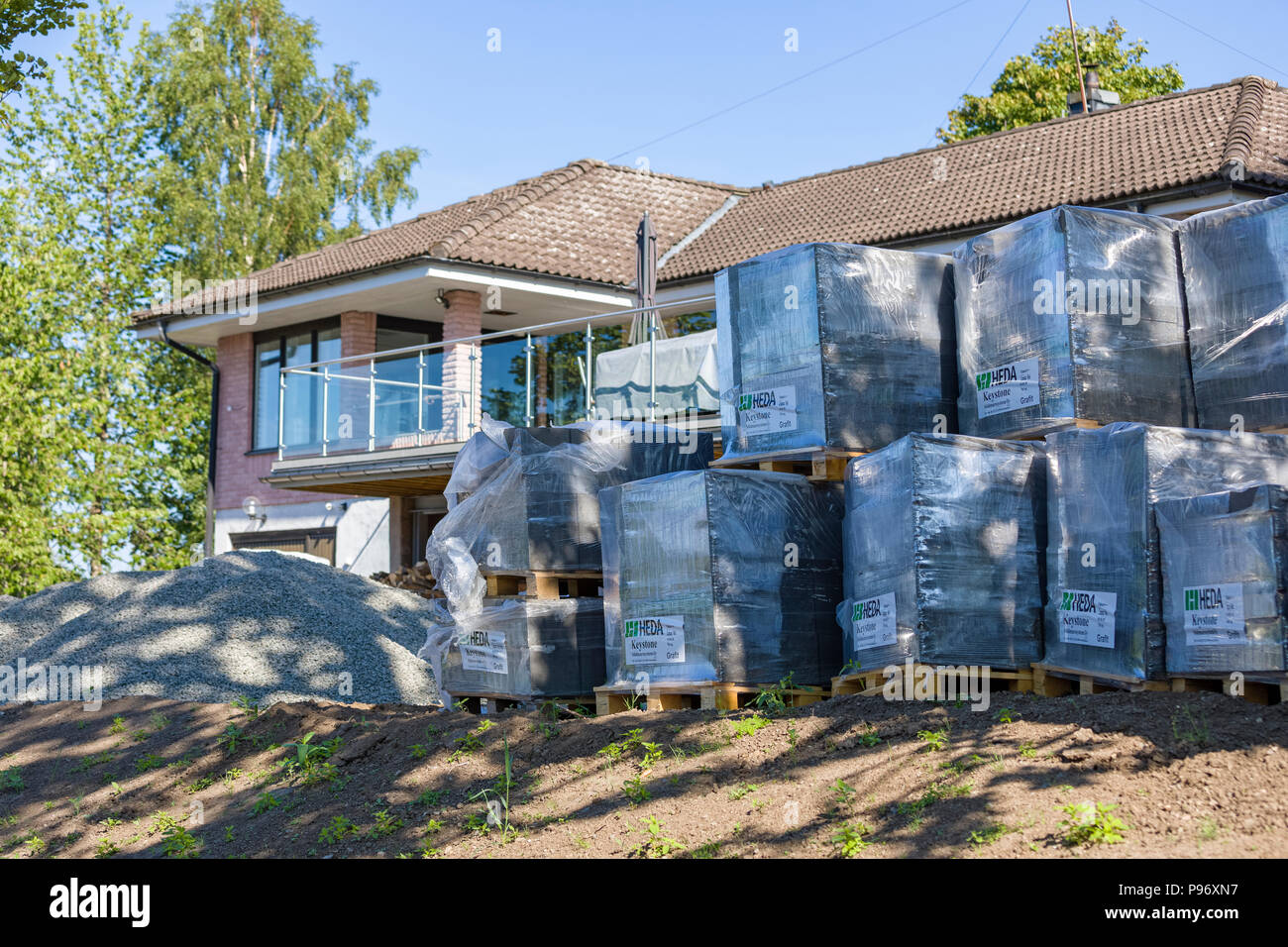 FLODA, SWEDEN - JULY 15 2018: Detached house undergoing home improvement and landscaping with front garden filled with building supplies such as brick Stock Photo