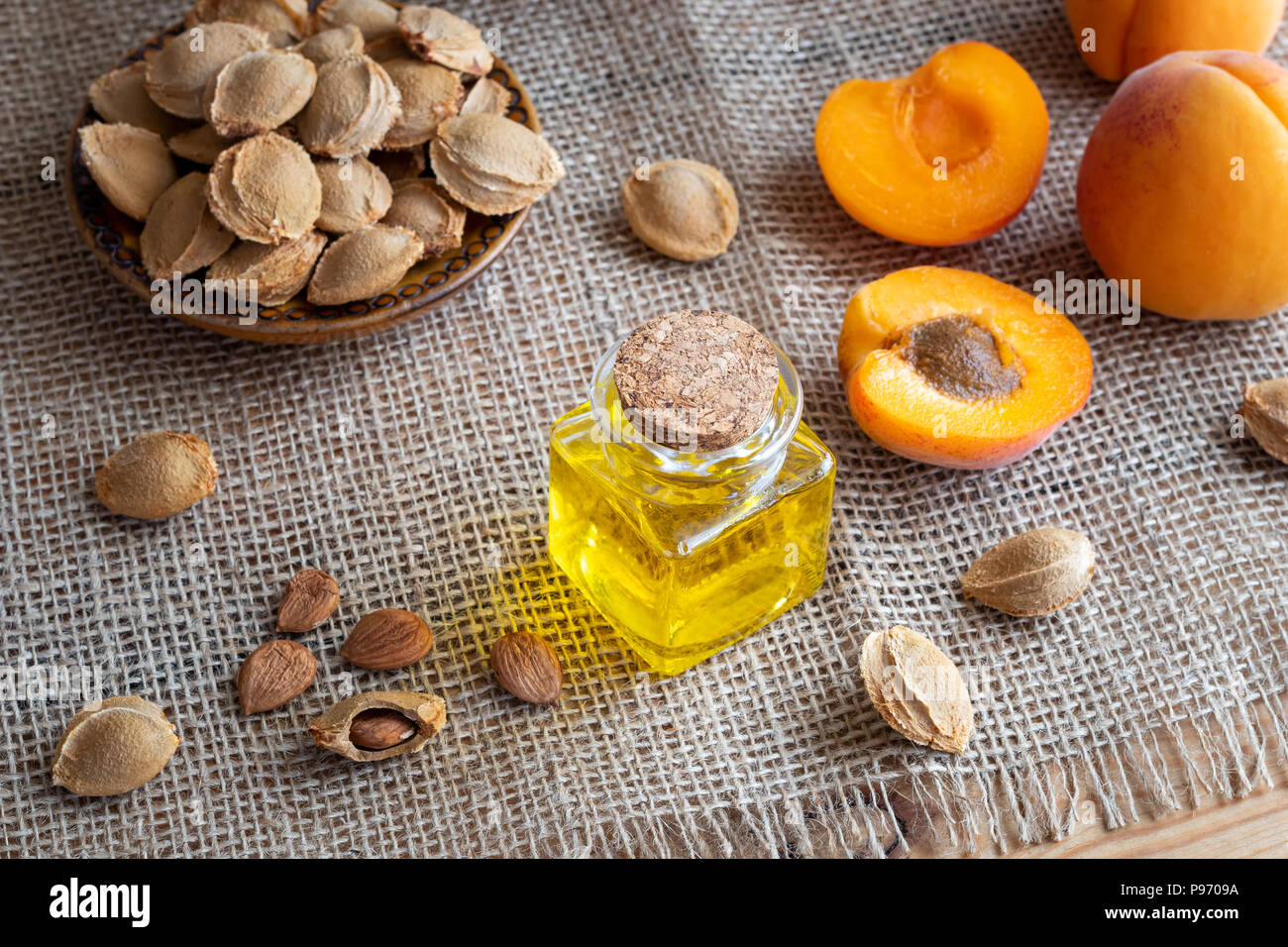 A bottle of apricot kernel oil with fresh fruit on a table Stock Photo