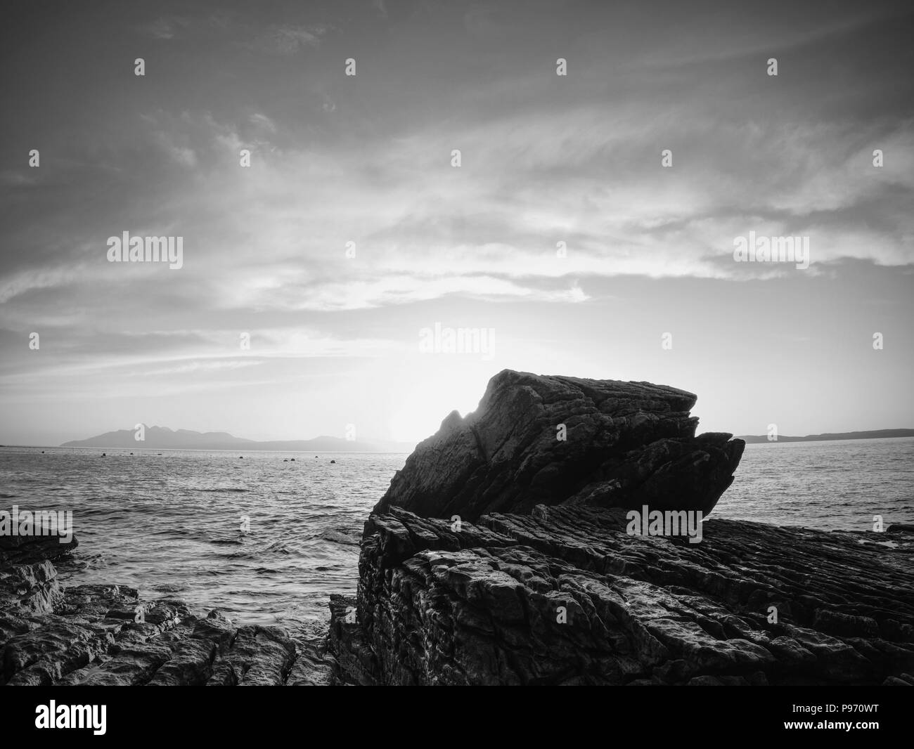 Rocky coastline in Elgol at sunset with cracked rocks in detail, Isle of Skye, Scotland. Blue shadows of cold February  dusk, clear sky. Stock Photo