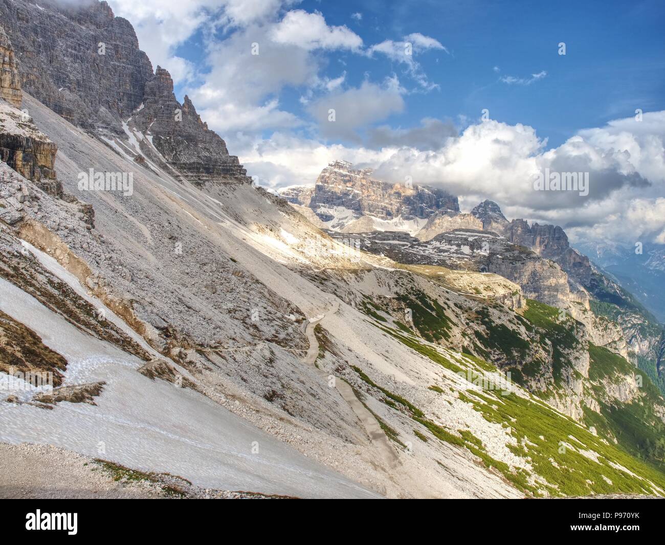 The rest of melting snow at gravel road in spring Alps mountains. View