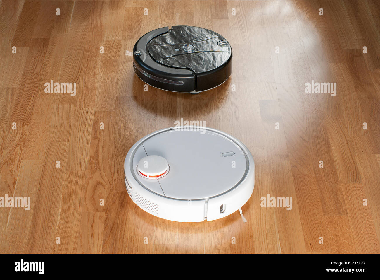 Two different robotic vacuum cleaners models cleaning dust. Modern