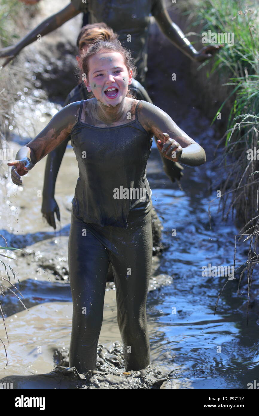 A girl crawling through a mud bath during a Young Mudder event in which ...