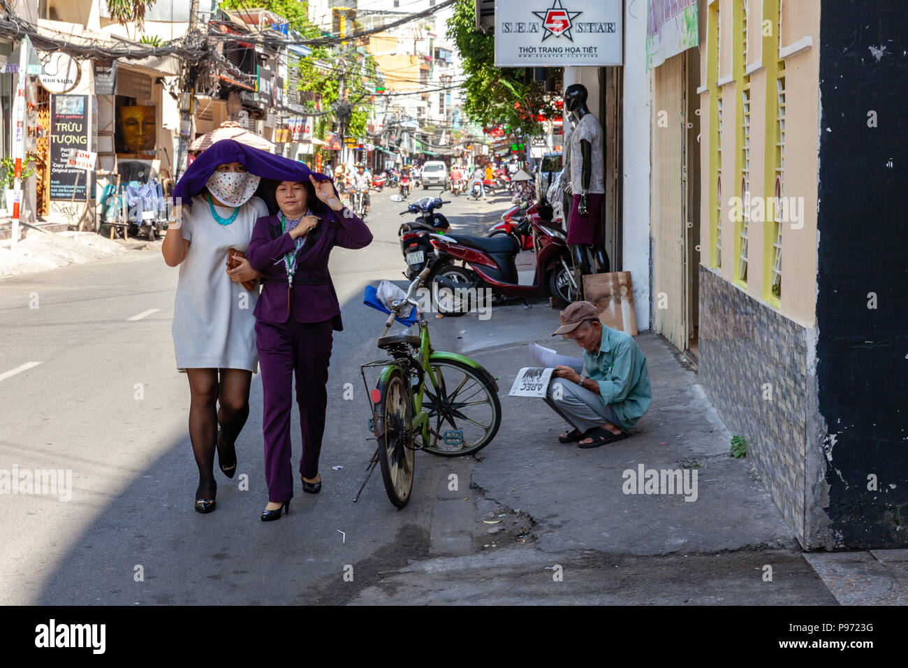 HO CHI MINH CITY, VIETNAM - NOVEMBER 20: Vietnamese women hide from the sun on Bui Vien Street in Ho Chi Minh City on November 20, 2015 in Ho Chi Minh Stock Photo