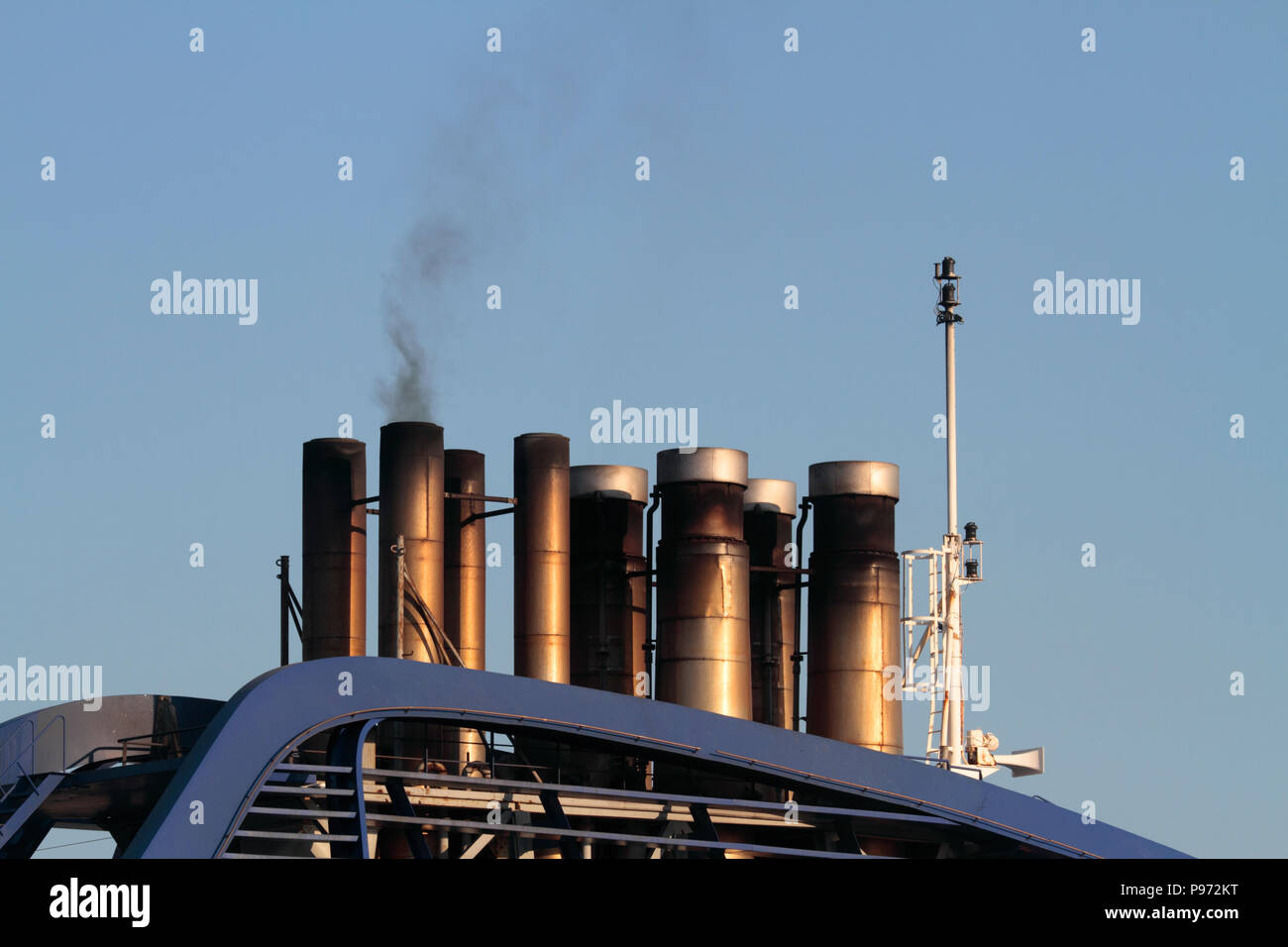 Smokestacks on a cruise ship emitting smoke while in harbour. Ships burning heavy fuel oil give rise to significant air pollution in harbour areas Stock Photo