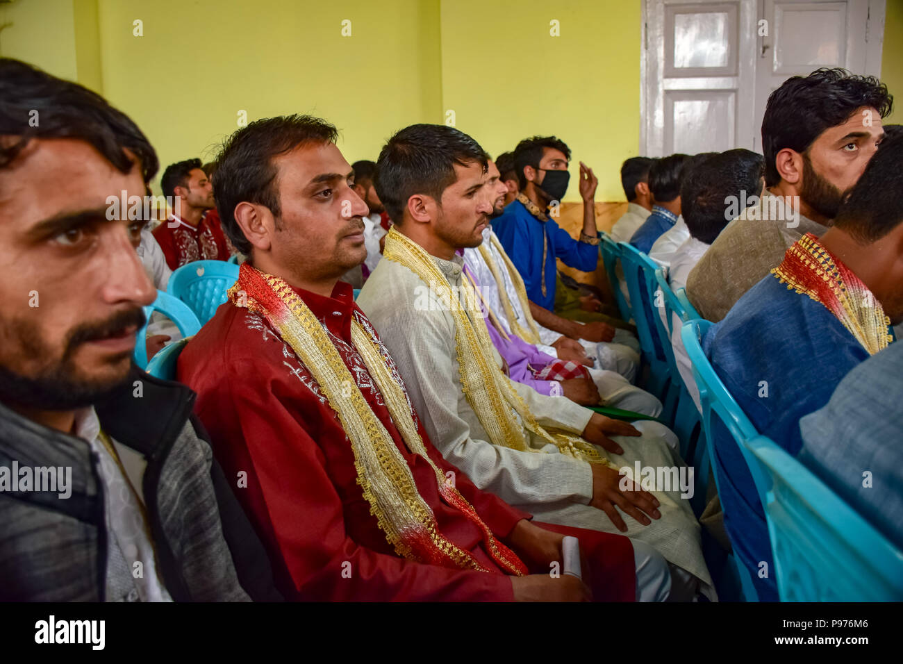 Srinagar, India. 15th July 2018. Kashmiri Muslim grooms sit for a mass marriage event in Srinagar, Indian controlled Kashmir on Sunday. Mass wedding of 105 Muslim couples held in Srinagar organised by social welfare organisation primarily to help the economically backward families who cannot afford the high costs of the ceremony, dowry and expensive gifts, that still prevails in many communities of India. Credit: SOPA Images Limited/Alamy Live News Stock Photo