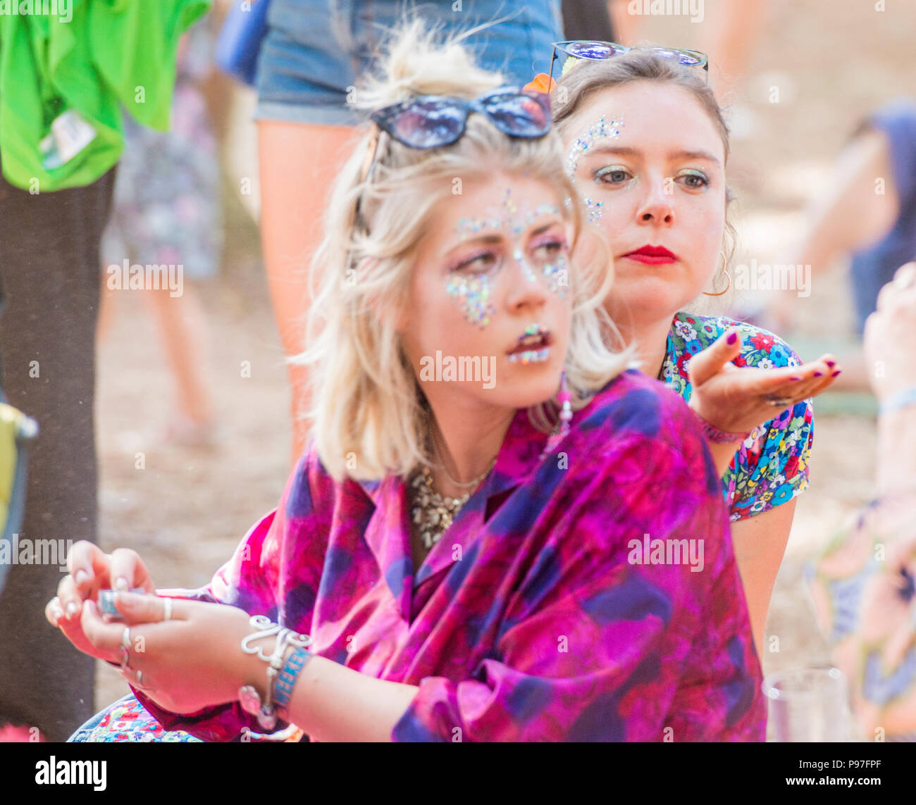 Two girls with painted faces, looking away, at Latitude Festival, Henham Park, Suffolk, England, 15th July, 2018 Stock Photo