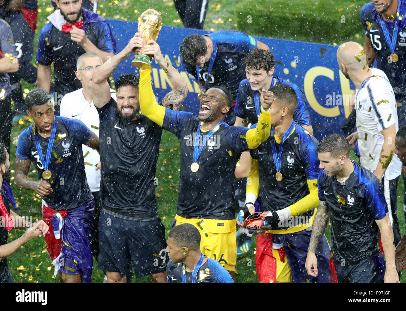France's Olivier Giroud (centre left) and goalkeeper Steve Mandanda celebrate trophy after winning the FIFA World Cup Final at the Luzhniki Stadium, Moscow. Stock Photo
