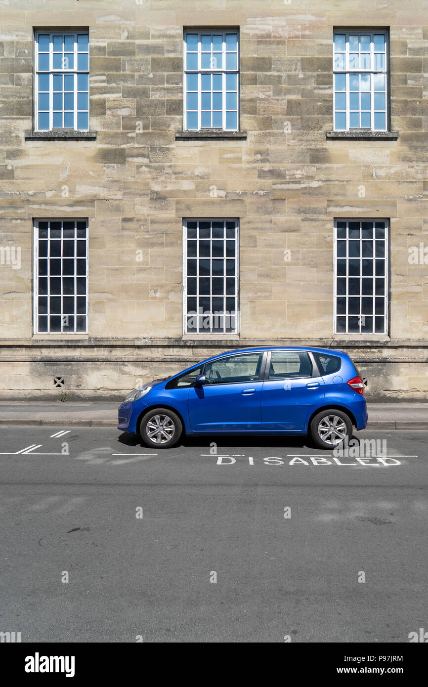 Blue car parked in disabled parking bay Stock Photo