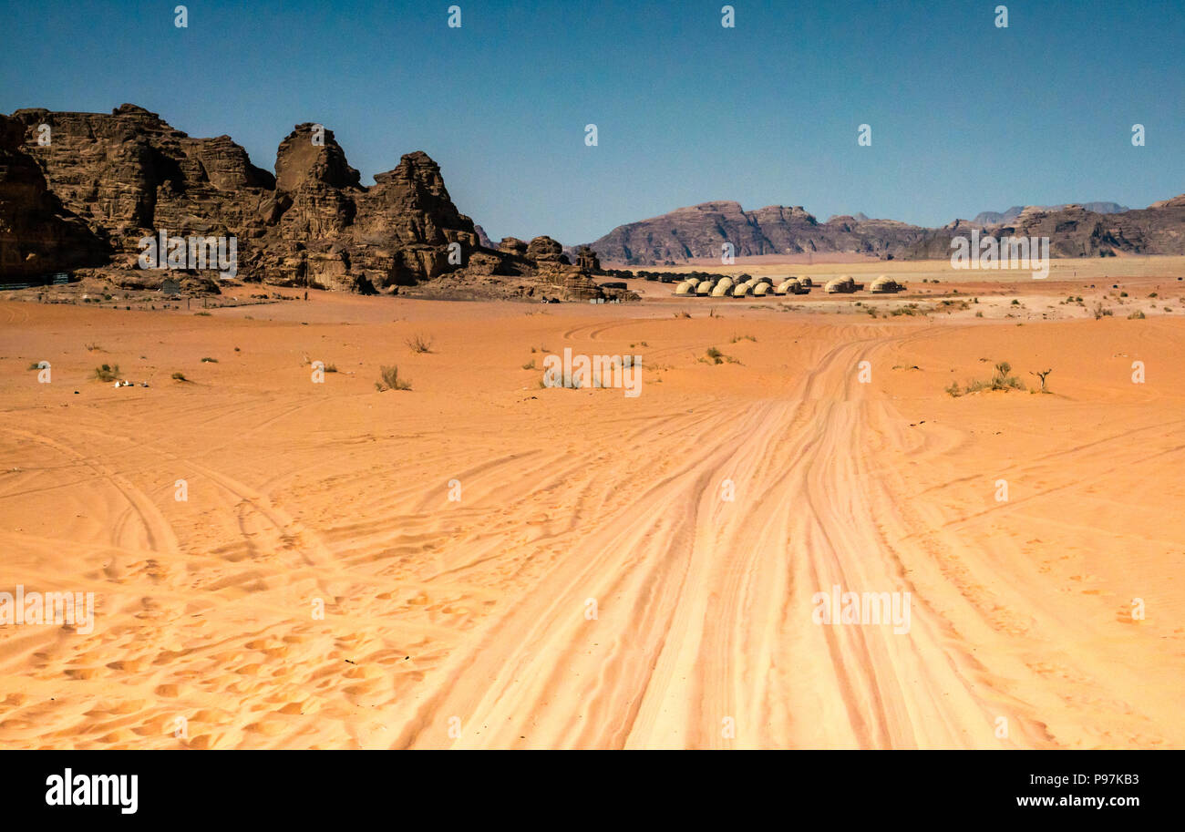 Desert landscape with 4x4  vehicle tracks in sand near Wadi Rum night luxury camp Jordan, Middle East Stock Photo