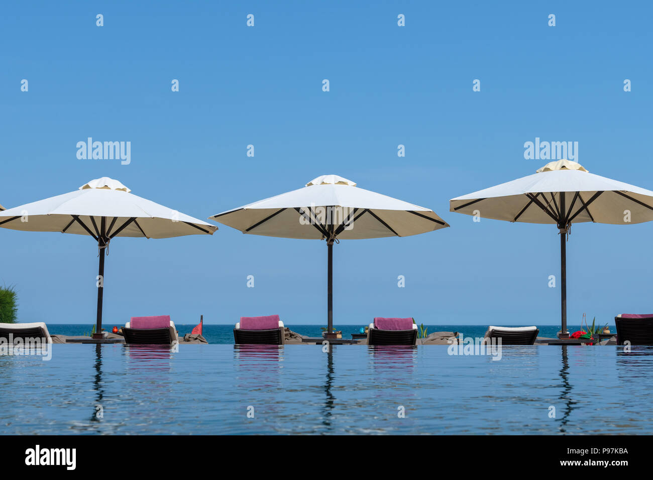 Sun loungers and umbrella shades by the sea Stock Photo