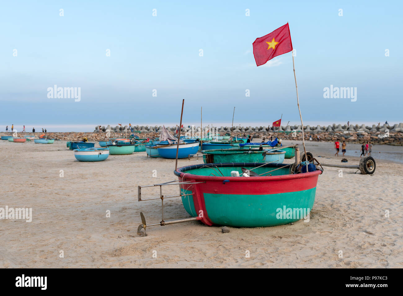 Small fishing boats on Mui Ne beach in southeast Vietnam.  People enjoying time on the beach Stock Photo