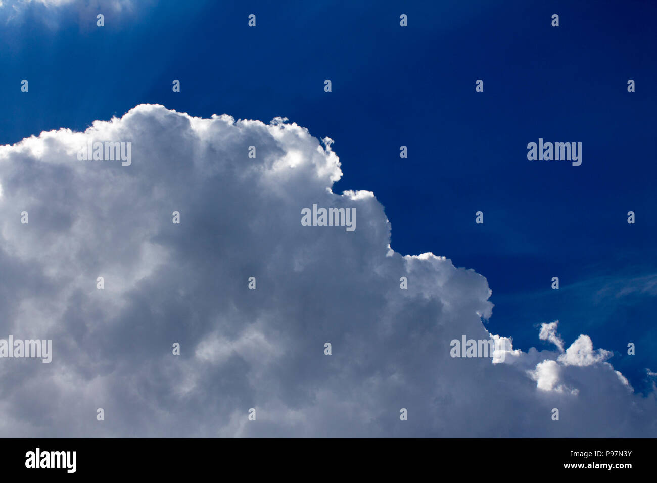 Photo of extremely fluffy clouds in the sky with sun rays Stock Photo