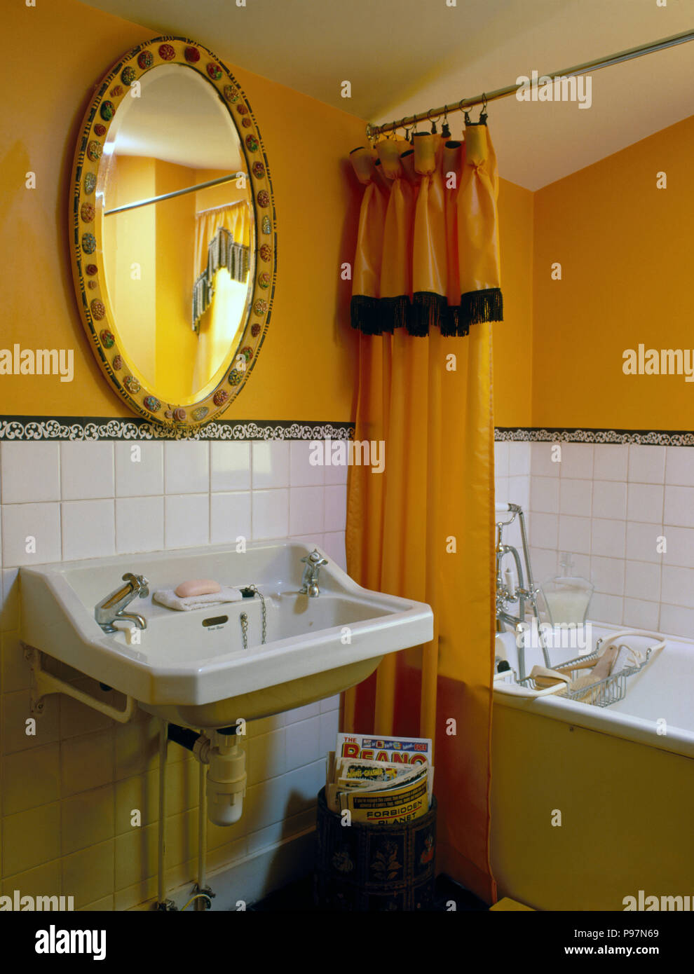 Oval Mirror Above Basin In A Bright Yellow Nineties Bathroom With