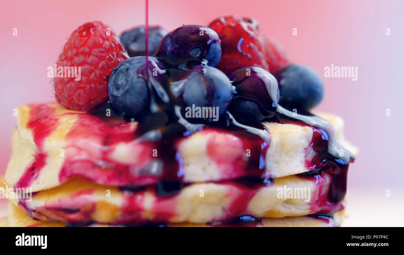 Stack of pancakes with raspberries, blueberries and drizzled with ...