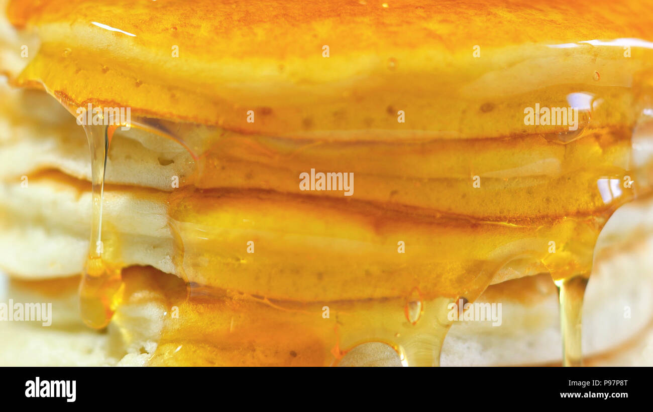 Stack of pancakes drizzled with syrup, macro closeup. Stock Photo