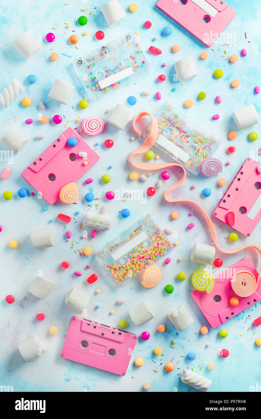 Pink cassette tapes in a sweet sounds concept. Candies, sprinkles and marmalades on a light background with copy space. Pastel color flat lay Stock Photo