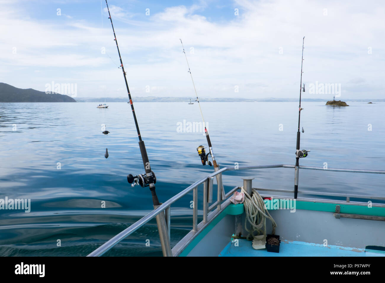 Fishing rods with reels on charter boat on tranquil day at sea in
