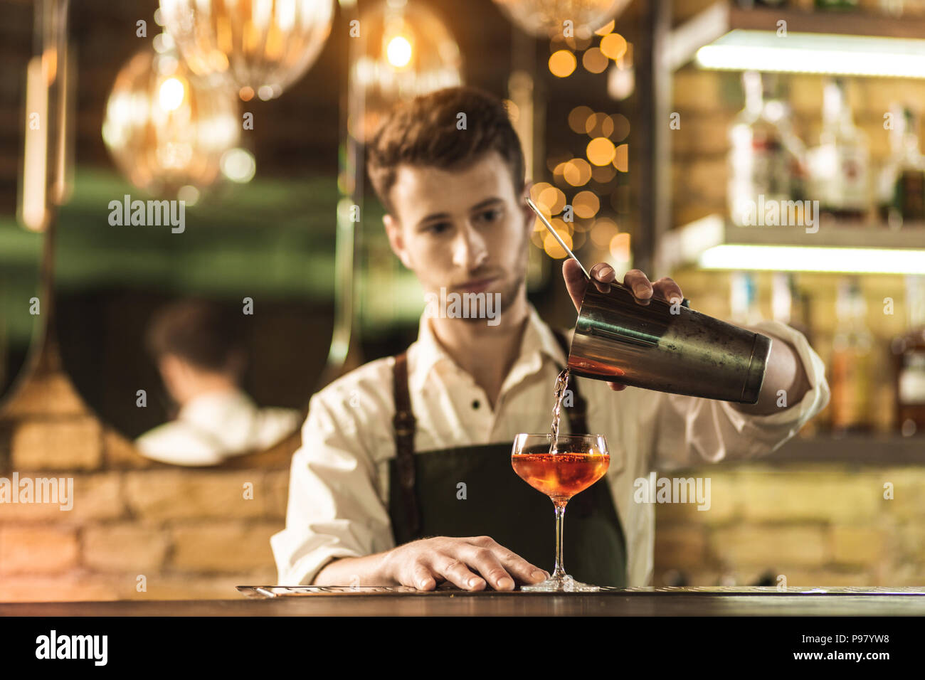 Pleasant young barman mixing a cocktail Stock Photo