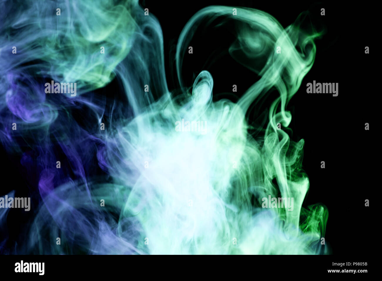 Blue and green cloud smoke on black isolated background Stock Photo - Alamy